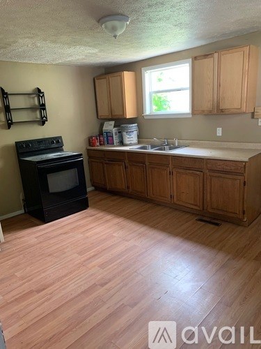 A kitchen with wooden floors and cabinets.