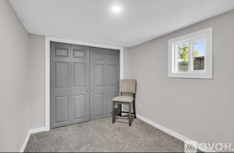 A room with grey carpet and white walls.