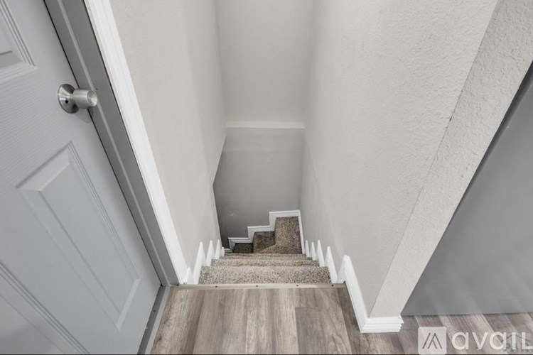 A staircase with a white door on the left side.