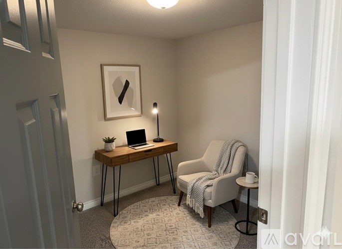 A room with a desk, chair, and lamp.