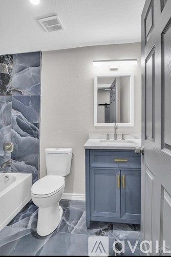 A room with a white wall and a grey carpet.