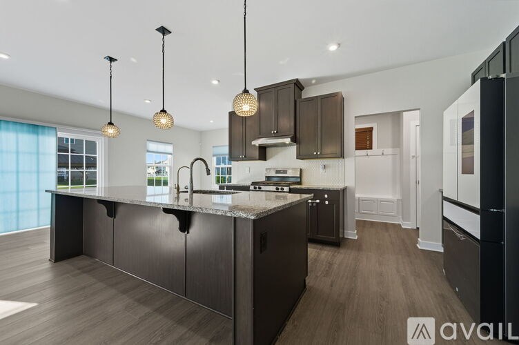 A modern kitchen with dark brown cabinets and a large island.