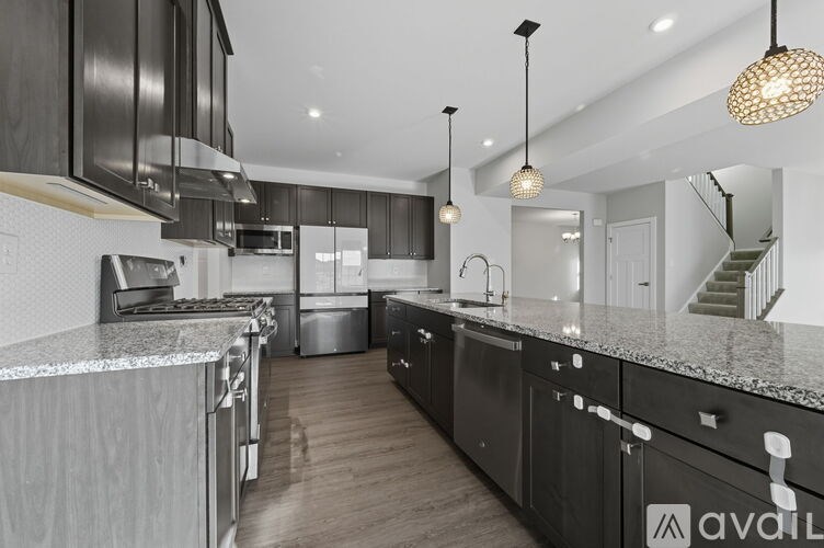 A modern kitchen with black cabinets and a marble countertop.