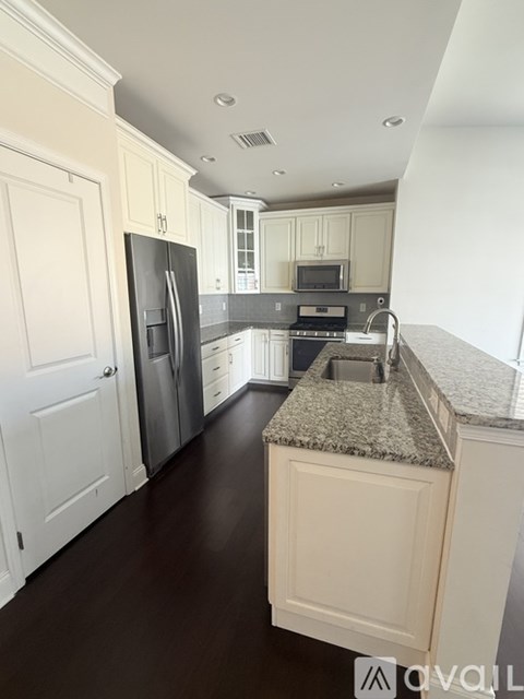 A kitchen with white cabinets and a granite counter top.
