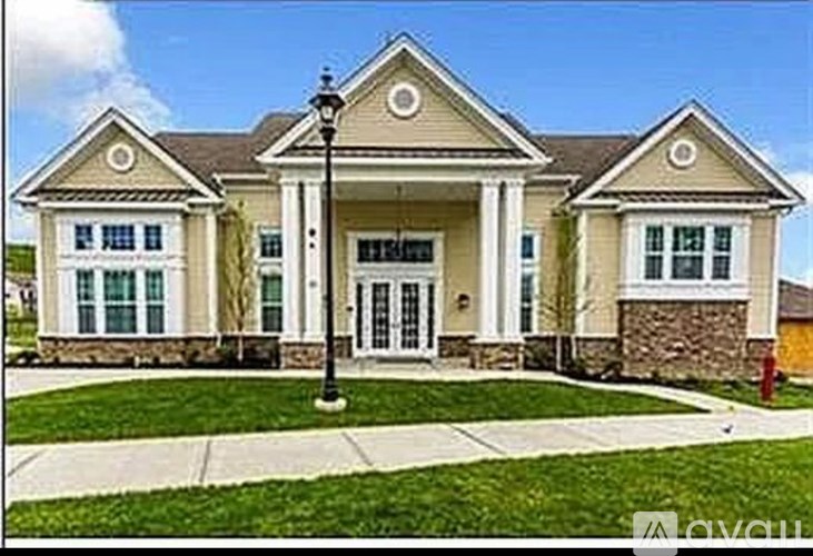 A two-story house with a front porch and a covered entrance.