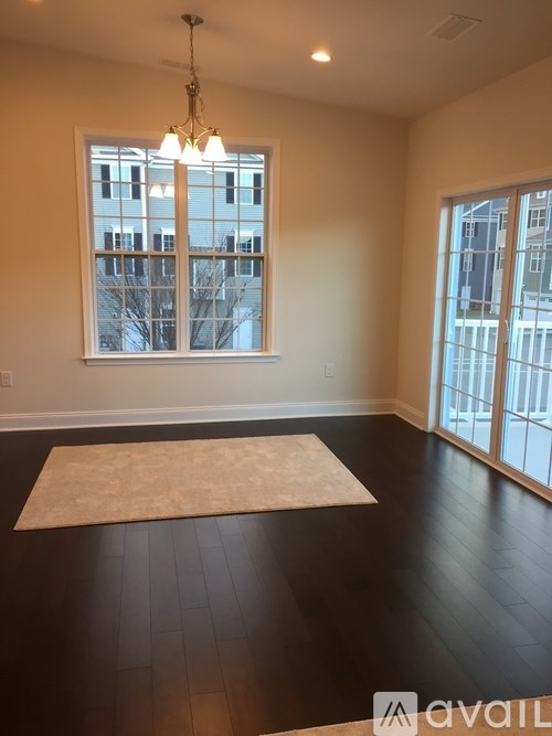A room with a large window and a rug on the floor.