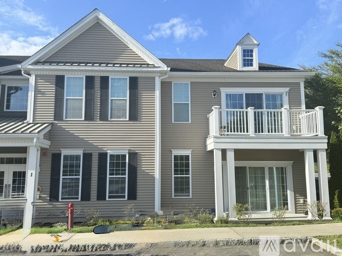 A two-story house with a balcony on the upper floor.