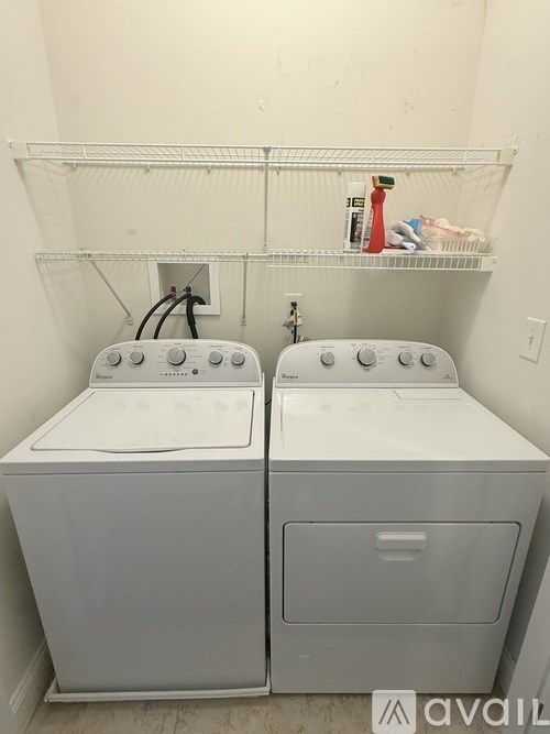 Two front loading washing machines in a small laundry room.