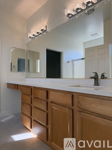 A bathroom with a glass shower door and a sink.