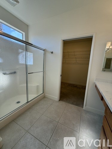 A house with a gravel driveway and a few plants in front.