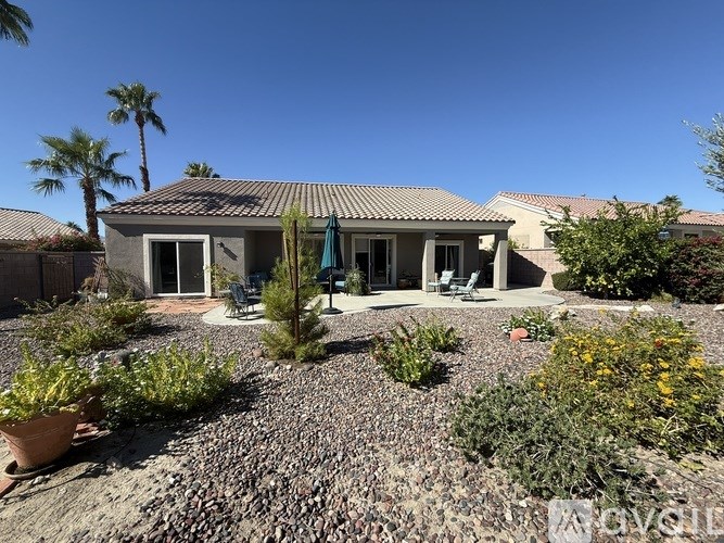 A house with a patio and a garden in front.