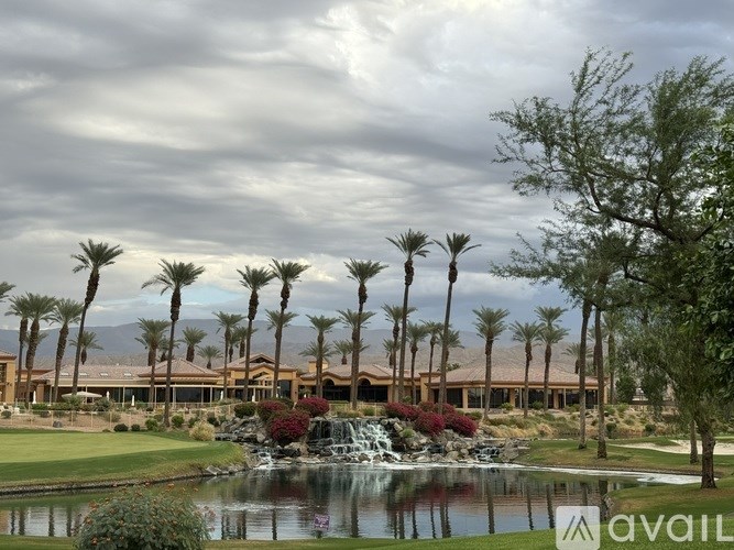 A golf course with a fountain and palm trees.