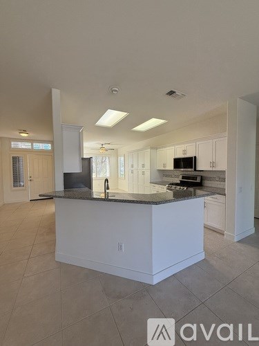 A room with a desk and a ceiling fan.
