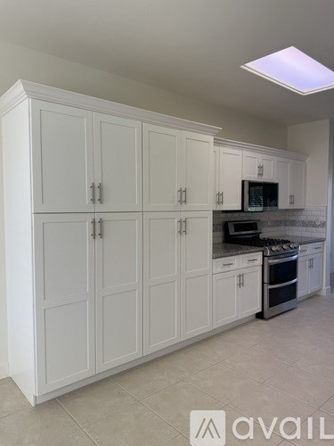 A living room with a couch, chairs, and a television.