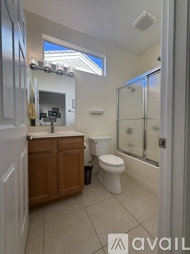 A bathroom with a toilet, sink, and shower.