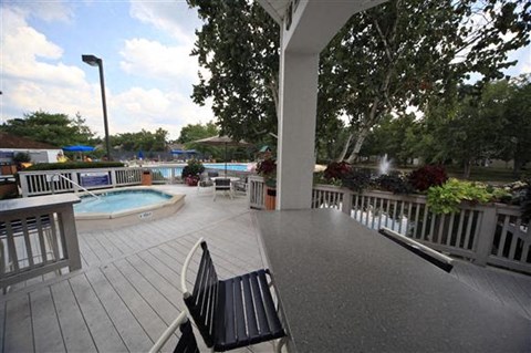 a patio with a table and chairs and a swimming pool