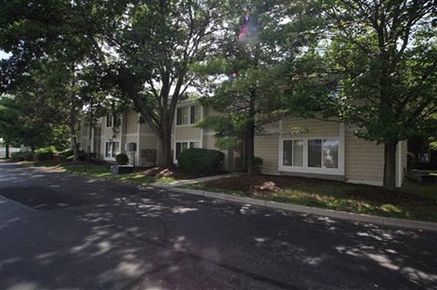 a street in front of a house with trees