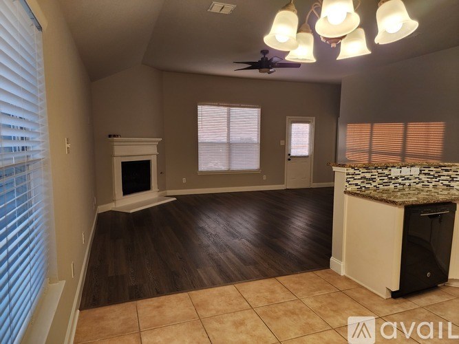 A living room with a fireplace and a ceiling fan.