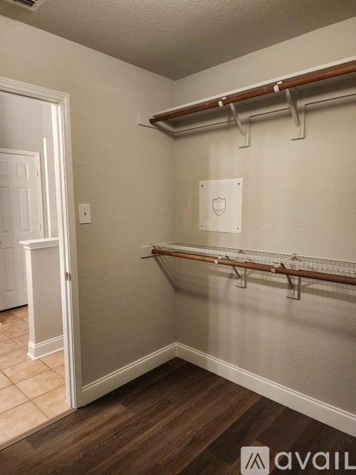 A white door is open to a room with a wall-mounted coat rack.