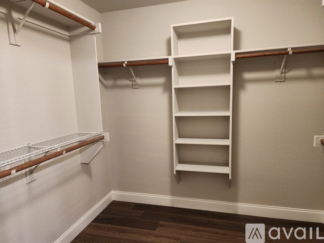 A white shelving unit with three shelves is mounted on a wall.