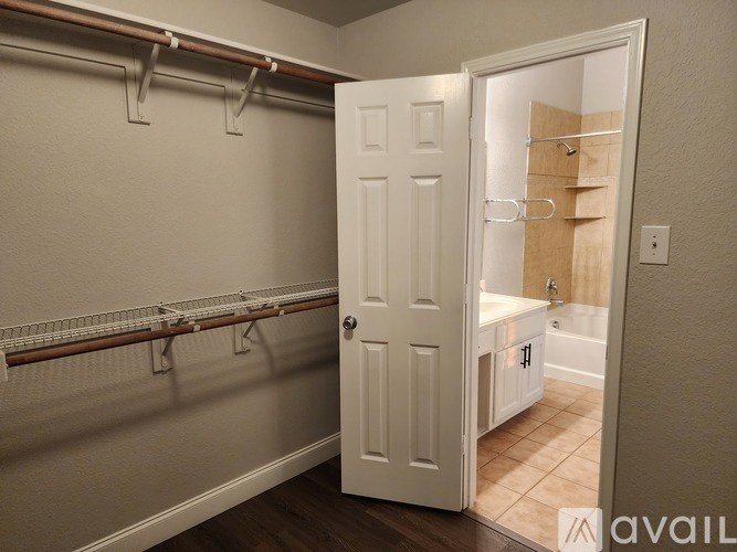 A white door is open to a bathroom with a towel rack on the wall.