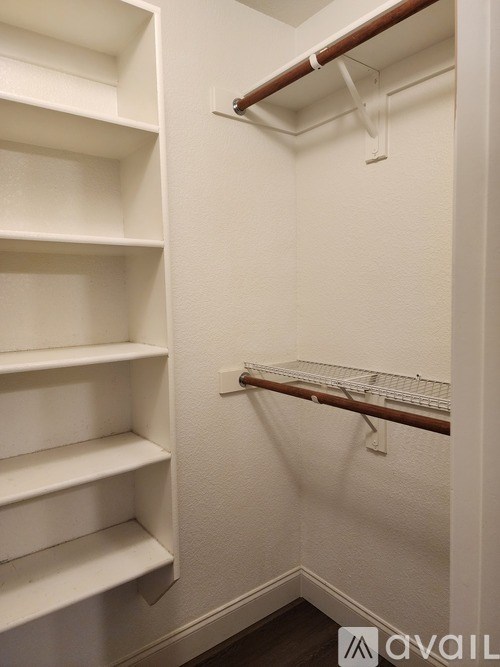 A white closet with shelves and a clothes hanger.