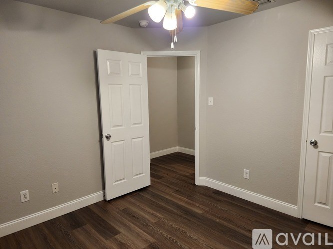A room with a white door and a chandelier hanging from the ceiling.