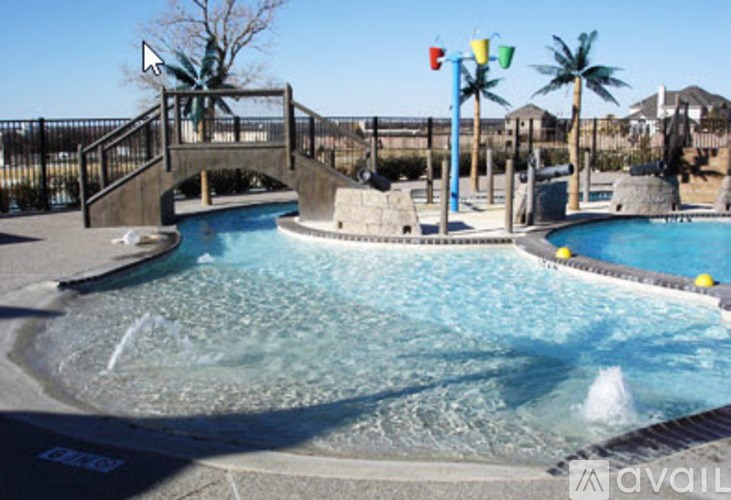 A pool with a bridge and palm trees in the background.