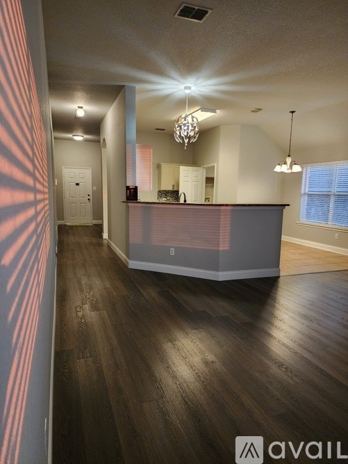 A spacious room with wooden floors and a reception desk.