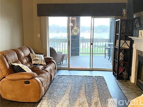 A brown leather couch with a pillow is in the living room.