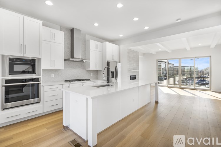 A modern kitchen with white cabinets and appliances.