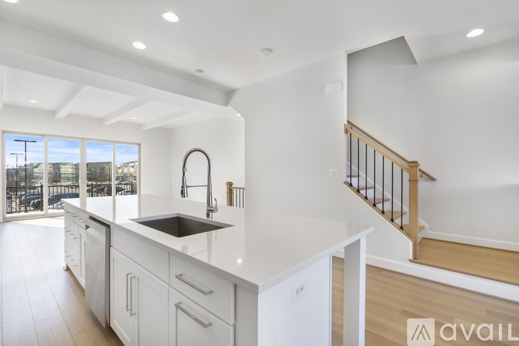 A modern kitchen with white cabinets and a stainless steel sink.