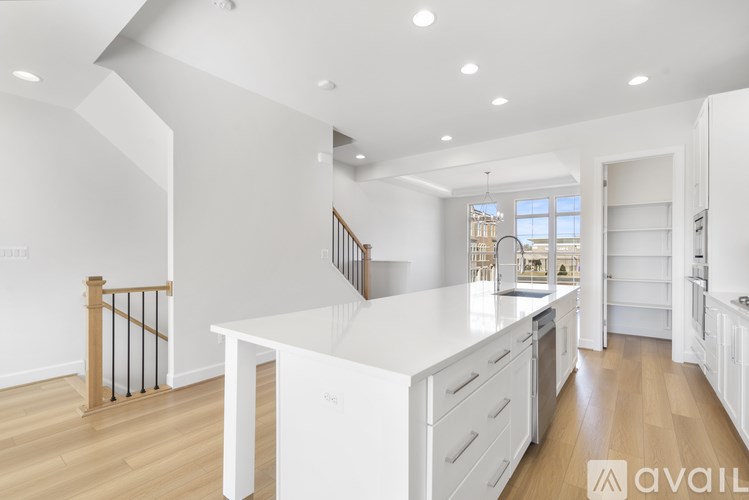 A spacious kitchen with white cabinets and a central island.