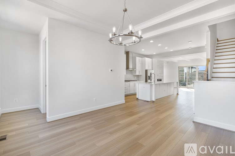A spacious kitchen with white cabinets and a wooden floor.