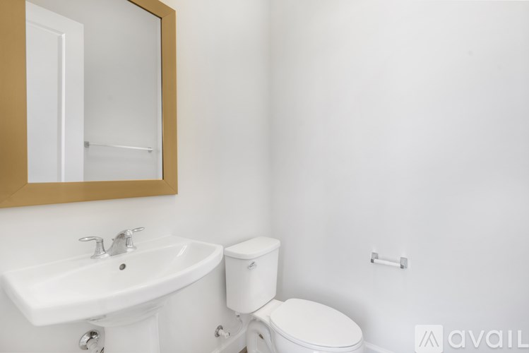 A white toilet sits next to a white sink in a bathroom.