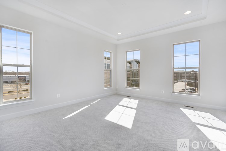 A large, empty room with a view of the outside through large windows.