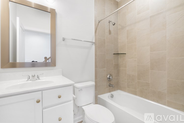 A bathroom with a white toilet, sink, and bathtub.