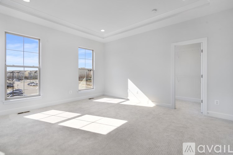 A large empty room with two windows and a door.