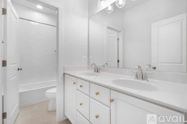 A white bathroom with a toilet, sink, and mirror.