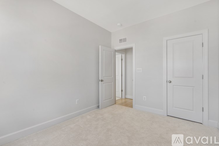 A room with two doors and a carpeted floor.