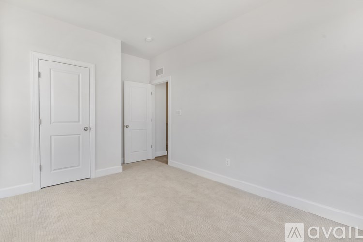 A room with two doors and a carpeted floor.