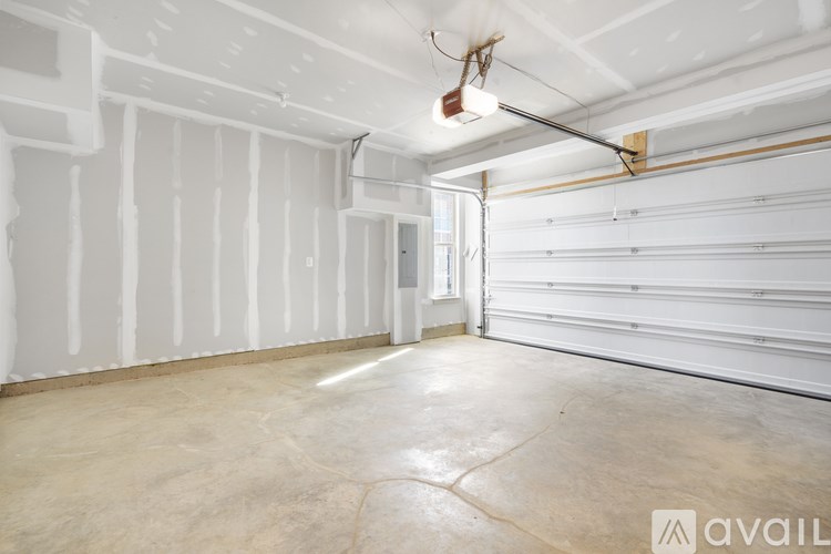 A spacious room with white walls and a concrete floor.