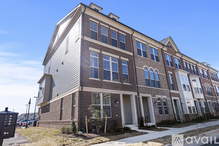 A row of townhouses with a sign that says "available" in front of them.