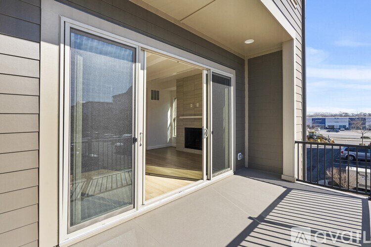 A balcony with a glass door leading to a room.