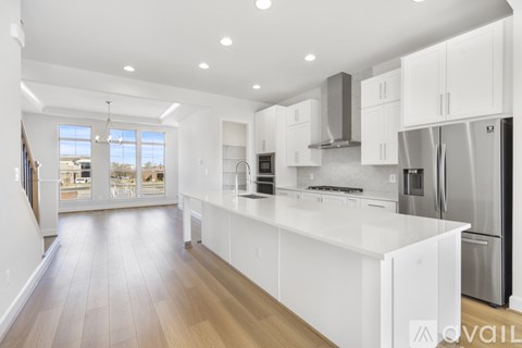 A modern kitchen with white cabinets and stainless steel appliances.