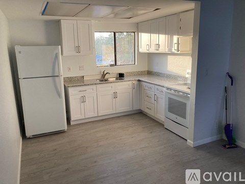 A kitchen with white appliances and cabinets.