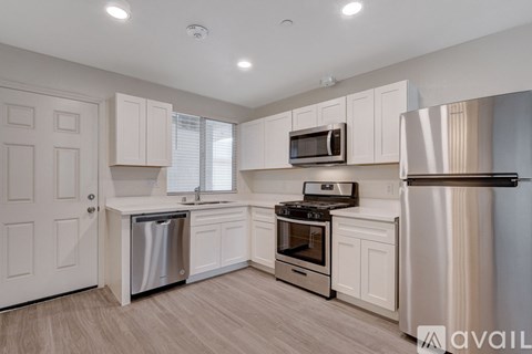 A kitchen with white cabinets and stainless steel appliances.