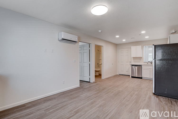 A kitchen area with a refrigerator, cabinets, and a dishwasher.