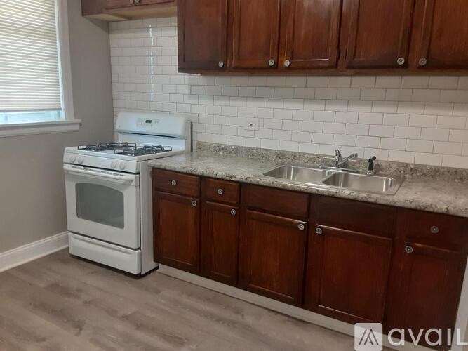 A kitchen with a white stove and brown cabinets.