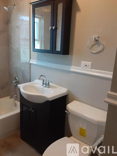 A small bathroom with a sink, toilet and a shower.